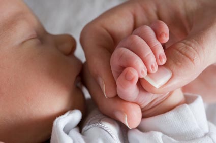 baby and parent holding hands